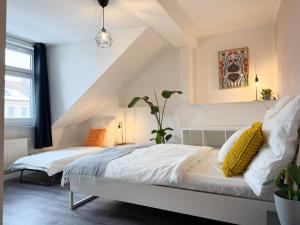 a bedroom with a bed with white sheets and yellow pillows at NEU - Gemütliches Apartment, Gruppen, Zentral in Erfurt