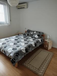 a bed with a black and white comforter in a room at Aoja in Maasmechelen