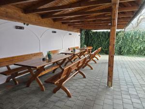 a row of wooden tables and benches in a pavilion at Pensiunea Transilvania in Sibiu