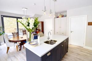 a kitchen with a sink and a table with a vase of flowers at 14 Dun Farraige in Cobh