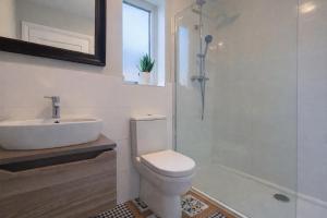 a bathroom with a toilet and a sink and a shower at 14 Dun Farraige in Cobh +15 photos