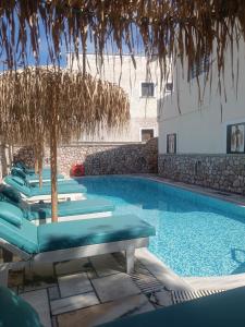 a swimming pool with chaise lounges and a swimming pool at Ifestia Hotel in Kamari