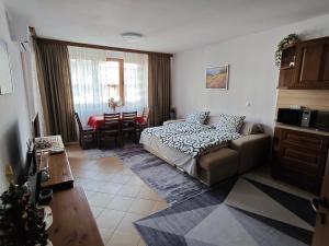 a bedroom with a bed and a living room with a table at Bansko Pirin Golf & Country Club Blue Mountains View in Razlog