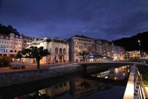 a bridge over a river in a city at night at Hotel Habsburg in České Hamry