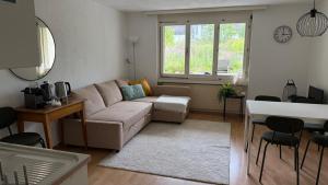 a living room with a couch and a table at Meiringen Retreat - Sauna, Terrace & Pinball in Meiringen