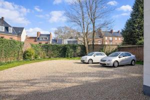 two cars parked in a driveway in front of a house at Hôtel Central Anzac Amiens Gare in Amiens