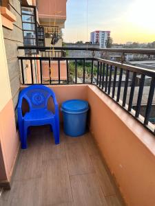 a blue chair and a trash can on a balcony at Serenity Homes in Ruiru