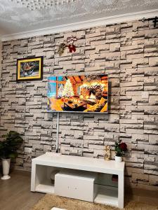 a living room with a tv on a brick wall at Serenity Homes in Ruiru +3 photos