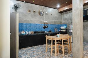 a kitchen with a wooden table and blue tiles at Urbanview Hotel Syariah Keys Banjarmasin by RedDoorz in Terantang