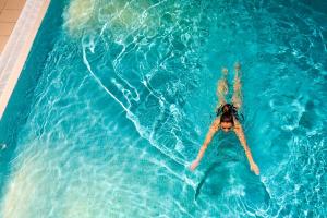 a woman laying on her back in a swimming pool at Underscar - Luxury 2 Bed Apartment in Keswick