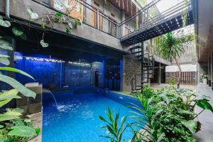 a swimming pool in the middle of a building with plants at Urbanview Hotel Syariah Keys Banjarmasin by RedDoorz in Terantang