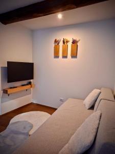 a bedroom with a bed and a flat screen tv at La Casa di Lumi in Lanzada