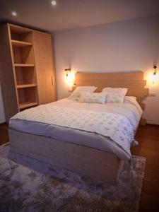 a bedroom with a large bed with a wooden headboard at La Casa di Lumi in Lanzada