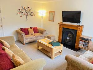 a living room with two couches and a fireplace at Cedar Place in Southwell in Southwell