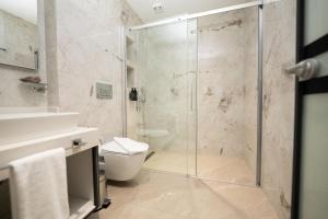 a bathroom with a shower and a toilet and a sink at Sunset Luxury Apartments in Keramoti