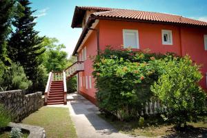 a red house with a staircase in front of it at Apartments in Lopar - Insel Rab 36282 in Lopar +20 photos