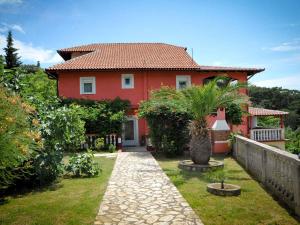 a red house with a pathway in front of it at Apartments in Lopar - Insel Rab 36282 in Lopar