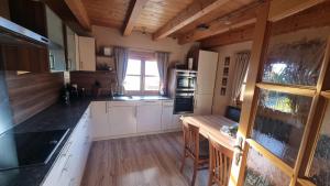 a kitchen with white cabinets and a wooden floor at Ferienhaus Kleinlercher in Iselsberg +16 photos