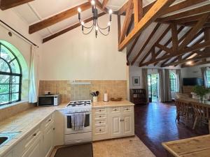 a kitchen with white cabinets and a stove top oven at Hornbill Cottage in Nairobi