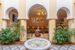 a lobby with a fountain in the middle of a building at Riad Amalia in Marrakesh