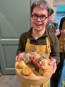 a man holding a plate of desserts on a table at Slapen Bij Brownies & Downies in Valkenswaard