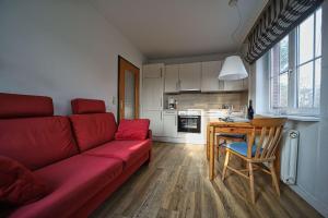 a living room with a red couch and a table at Appartement-8 in Süddorf