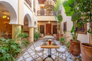 a courtyard with a table and chairs and plants at Riad Amalia in Marrakesh