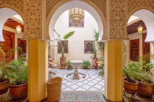 a courtyard with a fountain and potted plants at Riad Amalia in Marrakesh +87 photos