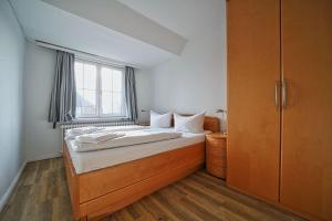 a bedroom with a large bed with a window at Appartement-8 in Süddorf