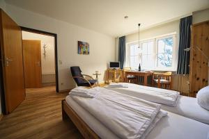 a hotel room with two beds and a desk with a computer at Appartement-4 in Süddorf