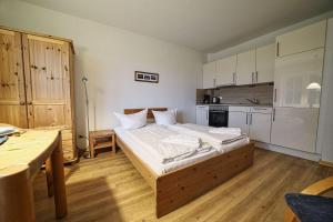 a bedroom with a large bed and a kitchen at Appartement-4 in Süddorf