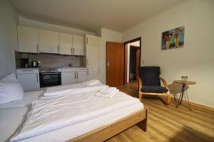 a room with two beds and a chair in it at Appartement-4 in Süddorf +12 photos