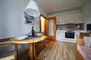 a kitchen and dining room with a wooden table at Appartement-3 in Süddorf