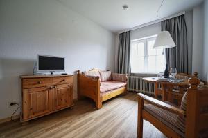 a living room with a couch and a television at Appartement-3 in Süddorf