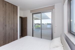 a bedroom with a white bed and a window at BlueBell Limassol Suites in Limassol +71 photos