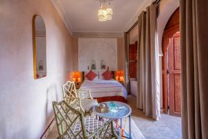 a bedroom with a bed and a table at Riad Amalia in Marrakesh