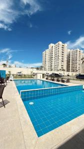 a swimming pool in front of some tall buildings at House098 in São Luís