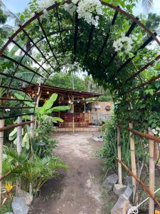 ein Torbogen mit einem Gebäude, das mit Blumen verziert ist in der Unterkunft Ubuntu Glamping - Adult Campers Only in Gili Trawangan