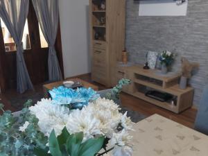 a vase of white flowers on a table in a living room at Brvnara Sofiana in Bajina Bašta