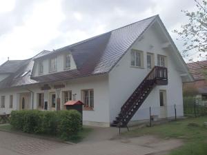 a white house with a metal roof and a staircase at Apartments in Trebbin 26568 in Trebbin