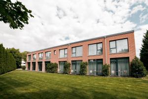 a brick building with a lawn in front of it at Privathotel alte mühle Wolfsburg-Weyhausen in Wolfsburg