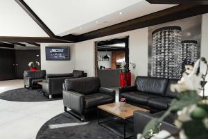 a waiting room with leather chairs and a table at Privathotel alte mühle Wolfsburg-Weyhausen in Wolfsburg