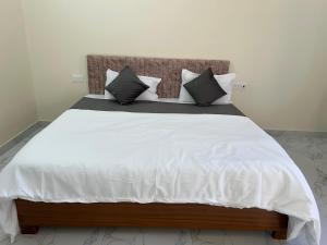 a large bed with white sheets and pillows at Hotel Pampa Sarovar in Chhatarpur