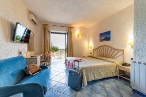 a hotel room with a bed and a couch at Punta Chiarito Resort in Forio d'Ischia