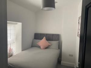 a bedroom with a bed with a pink pillow on it at The Woodquay House in Galway