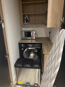 a small kitchen with a washing machine and a microwave at The Woodquay House in Galway