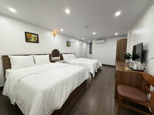 a hotel room with two beds and a television at Galaxy Airport Hotel in Hanoi +51 photos