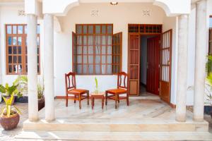 two chairs and a table on the porch of a house at Arusha 2bedroom in Arusha