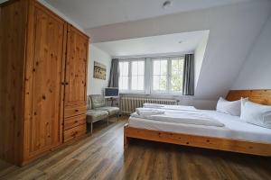 a bedroom with a bed and a large wooden cabinet at Appartement-7 in Süddorf