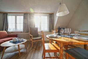 a living room with a table and a dining room at Appartement-5 in Süddorf +13 photos